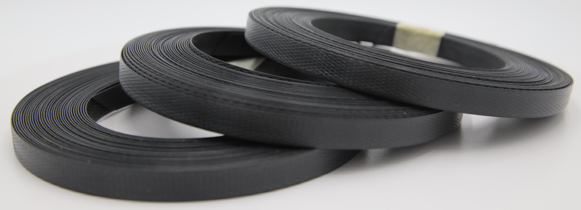 3 black polypropylene strapping reels laying ontop eachother